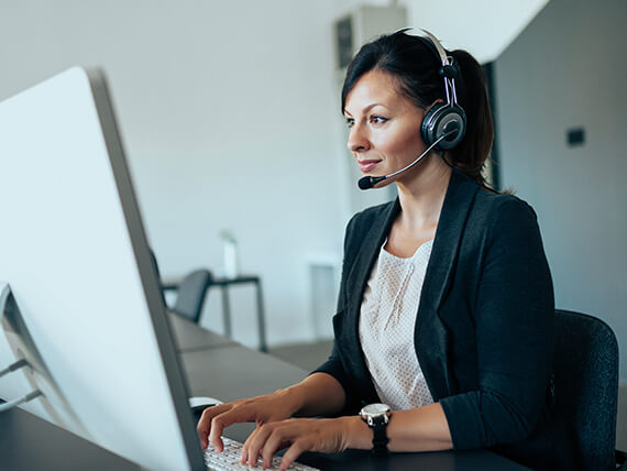 Businesswoman working with headset on computer
